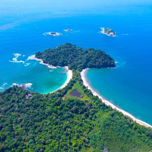 Stunning aerial shot of the lush coastline and turquoise waters of Manuel Antonio National Park, Costa Rica.