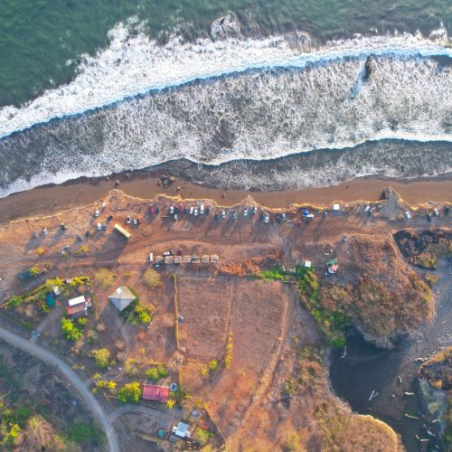 A breathtaking aerial view of Bajamar's coastline in Costa Rica, featuring waves crashing on the shore.
