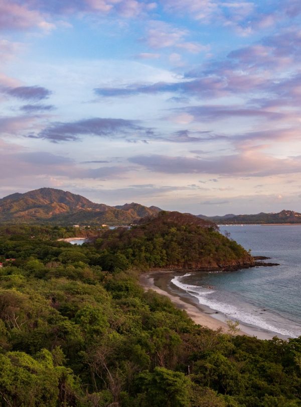 Karibu Kenya Safaris - A stunning aerial view of the Guanacaste coastline at sunset with lush greenery and gentle waves.