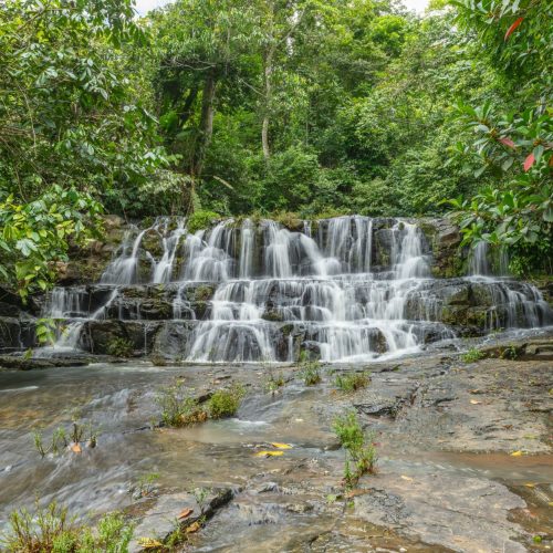 Beautiful cascading waterfall surrounded by lush green rainforest in Costa Rica.