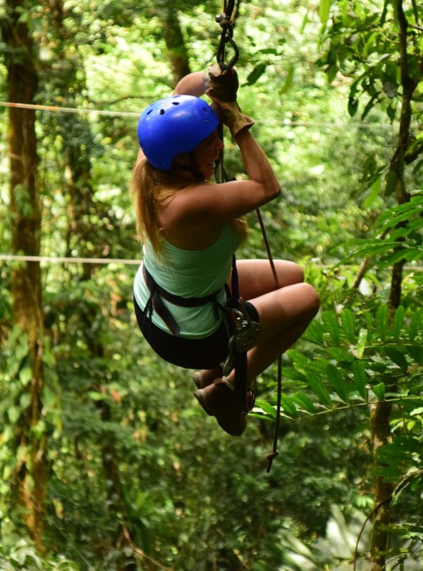 Karibu Kenya Safaris - A woman ziplining through lush Costa Rican forests, showcasing adventure and nature.